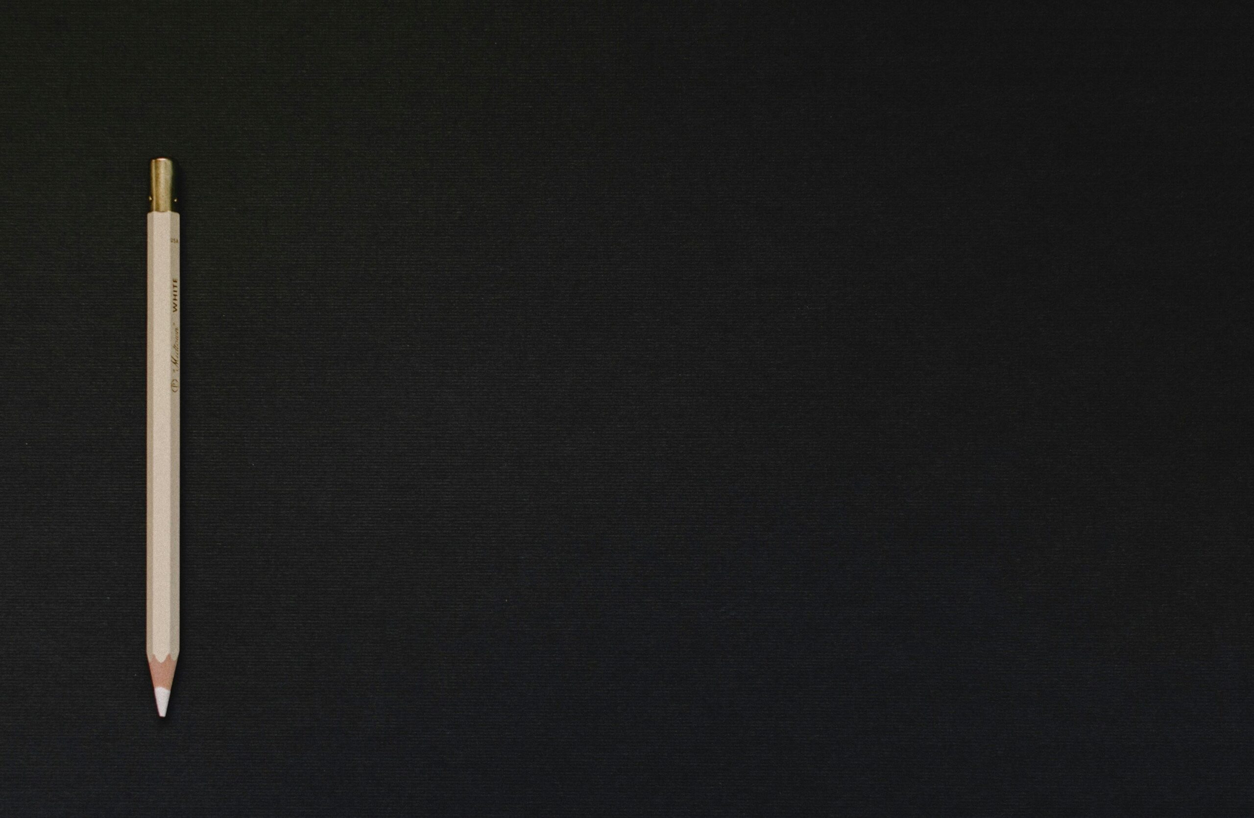 Crayon de couleur blanc posé sur un fond noir